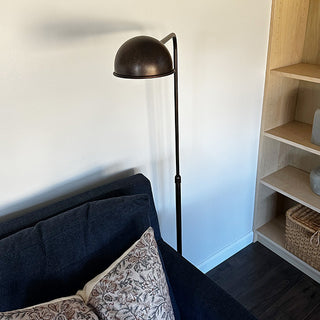 Black floor lamp beside navy sofa and shelves