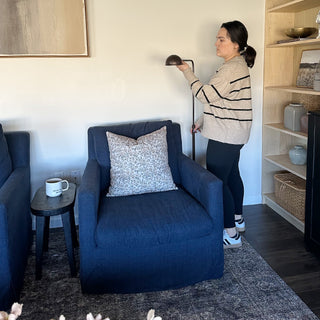 Woman adjusting height of black floor lamp