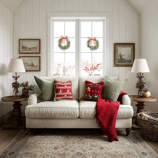 Cozy holiday living room with white sofa, festive throw pillows, and deer-themed table lamps on wooden end tables