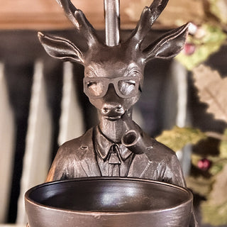 Close-up of bronze male deer lamp base with antlers, glasses, and pipe, holding decorative bowl
