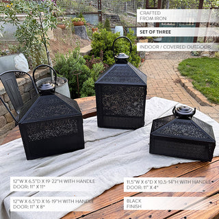 Set of three black iron lanterns shown outdoors on a rustic table, highlighting size variations, perforated metal design, and product dimensions.