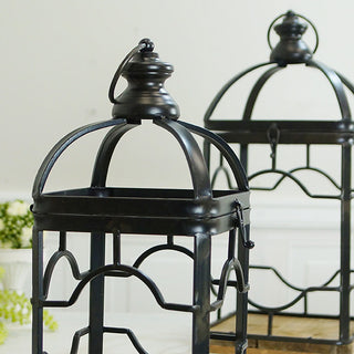 Close-up of arched dome top with decorative finial and loop handle on black metal glass panel lantern 