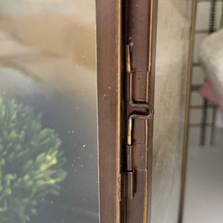 Close-up of bronze lantern hinge detail showing craftsmanship and distressed metal finish