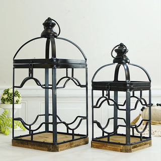 Side view of black metal lantern set showing ornamental fretwork pattern and clear glass panel construction