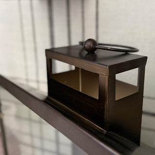 Close-up of bronze lantern top with round handle and open-air vent design highlighting metalwork and finish