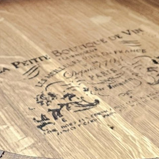 Close up of French cooperage markings and authentic distillery stamps on bourbon barrel wood lazy susan surface