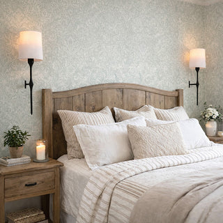 Battery operated wall sconces with white fabric shades mounted beside bed in modern farmhouse bedroom