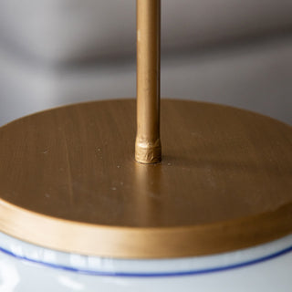 Close-up of gold canopy and rod attachment on porcelain pendant light