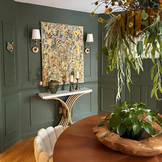 Elegant entryway featuring botanical gold wall sconces above marble console table