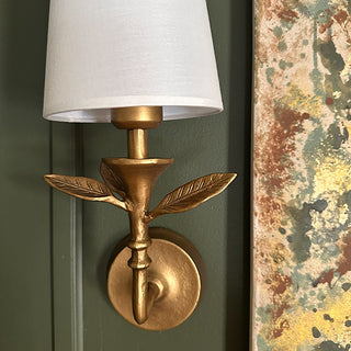 Detailed view of cordless LED wall sconce with dimensional leaf accents and white shade