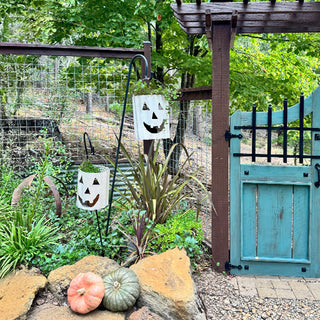 Hanging metal pumpkin face lanterns used as planters