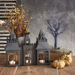 Halloween haunted house candle holder centerpiece styled with pumpkins, fall branches, and spooky tree decoration