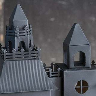 Detailed view of haunted house candle holder rooftop spires and gothic fence design in black metal