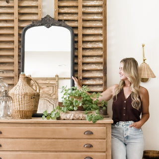  Ornate arched wall mirror with baroque crest displayed on rustic wood shutters background