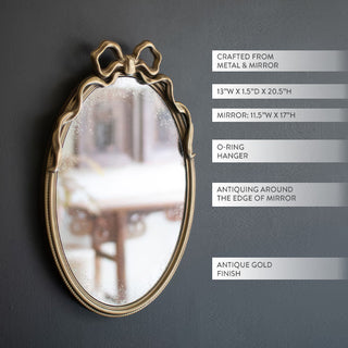 Vintage oval wall mirror with bow detail and antiqued mirror edge showing dimensions and features on dark background