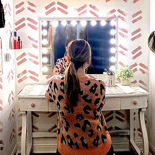 Woman using illuminated vanity mirror makeup desk