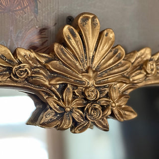 Ornate floral gold mirror frame detail close-up