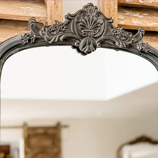Ornate mirror crest detail showing hand-carved baroque style embellishments and vintage finish