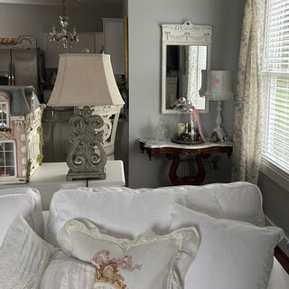 Distressed white mirror above rustic entry table