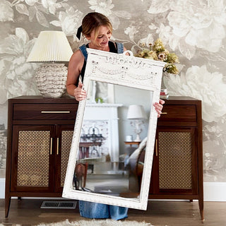 Woman displaying large distressed white decorative mirror