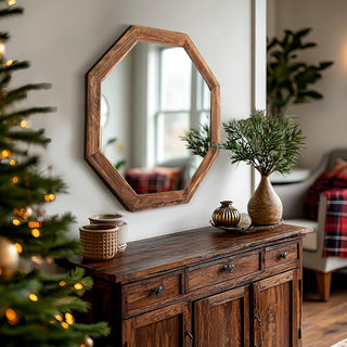 Octagon wood-framed wall mirror styled on a rustic console table with holiday decor in a cozy living room.