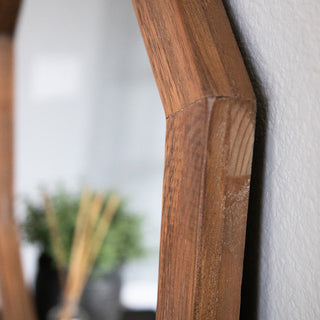 Close-up detail of the octagon mirror’s natural wood grain frame for product texture and quality showcase.