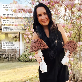 Distressed iron mushroom decor set held outdoors