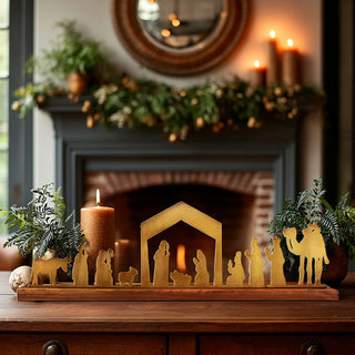 Brass nativity scene decor on wooden base displayed on holiday mantel with candles and greenery, elegant Christmas home décor accent