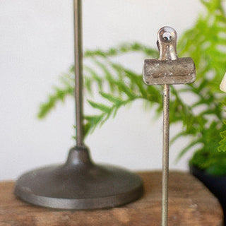 Detail view of distressed metal pedestal base and clip mechanism on vintage note holder stand