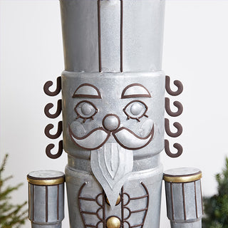 Close up detail of galvanized nutcracker face showing hand painted bronze curled mustache gold accents and dimensional metal craftsmanship