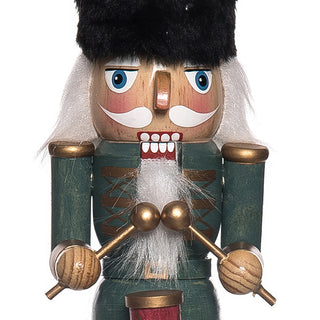 Close-up detail of green soldier nutcracker with black fur hat white beard and hand-painted facial features
