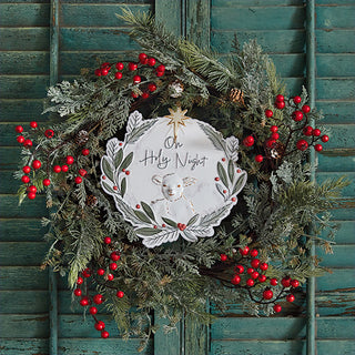 Christmas wreath decorated with Oh Holy Night metal ornament evergreen and red berries