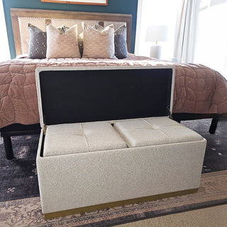 Boucle upholstered ottoman bench with gold base positioned at foot of bed in modern bedroom