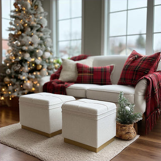 Two cream boucle storage ottomans with gold metal legs flanking small decorative Christmas tree in living room