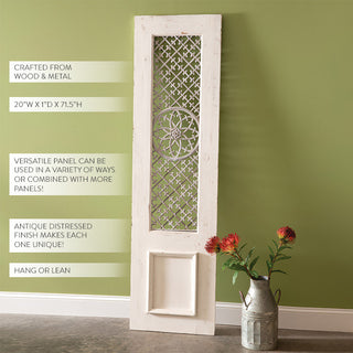 Tall white wood door panel with ornate metal lattice work and floral medallion centerpiece leaning against green wall