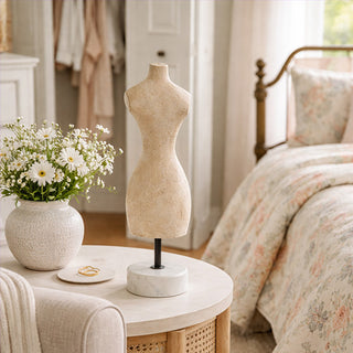 Vintage paper mache dress form on marble base styled on bedroom nightstand
