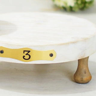 Close-up of large pedestal riser with gold number 3 plate showing wood grain texture