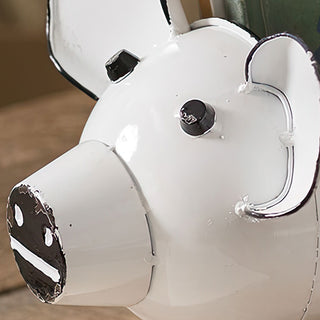 Close-up distressed white metal pig decor