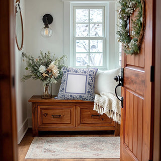 Nestled hallway with wooden bench, floral arrangement, and decorative pillows.