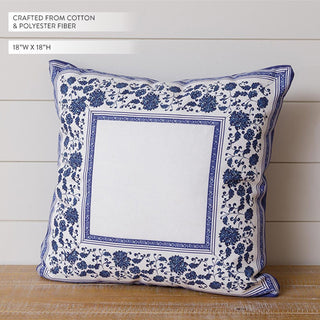 Decorative pillow with blue floral pattern on a wooden surface and light wooden panel background