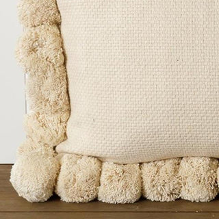  Close-up detail of cream pom pom pillow border showing textured woven fabric and plump pom pom trim craftsmanship