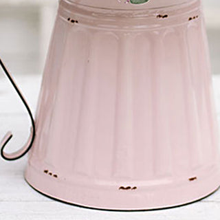 Close up of distressed pink finish and worn patina on metal pitcher base