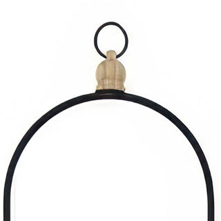 Decorative wood finial detail on black arch handle planter