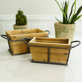 Two natural wood nesting planter boxes with metal frames displayed with potted plants on white surface