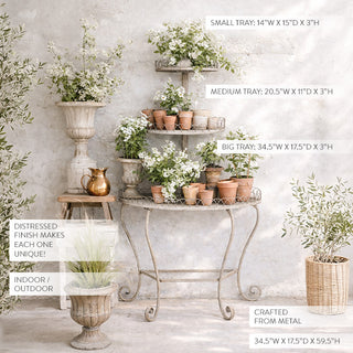 Decorative metal plant stand with potted plants against a light gray wall.