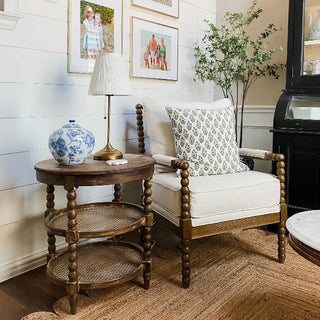 Wooden chair with white cushion and decorative pillow next to a wooden side table with lamp and Chinoiserie Ginger Jar in a cozy living room.