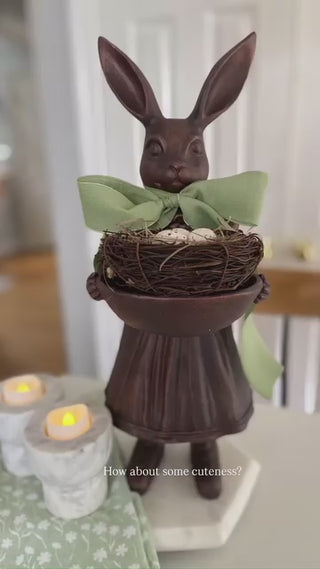 Full view Female Royal Hare statue bronze finish resin pleated dress mary jane shoes holding decorative bowl wearing green bow and holding bowl with nest of eggs
