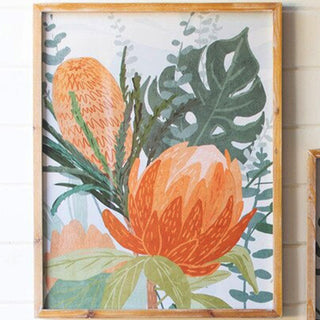 Single botanical protea framed wall art print with monstera leaves and orange flowers in natural wood frame on white shiplap wall