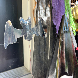 Close-up of black metal bat accent on Halloween witch hat décor
