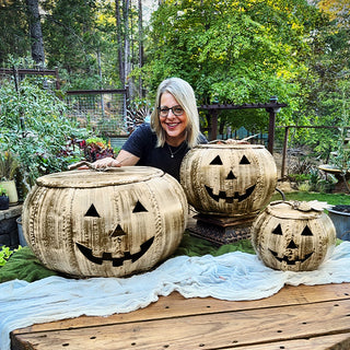 Woman posing with three distressed metal jack-o'-lantern